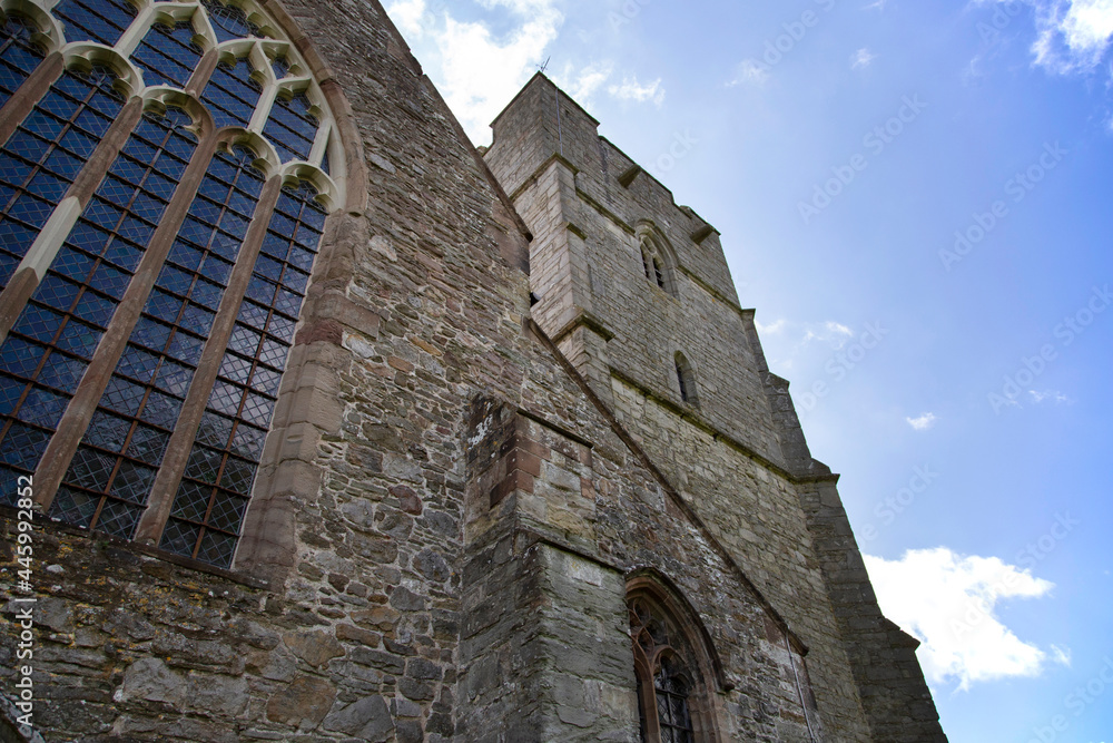 Presteigne church window and tower in Powys, Wales.  With a blue sky background