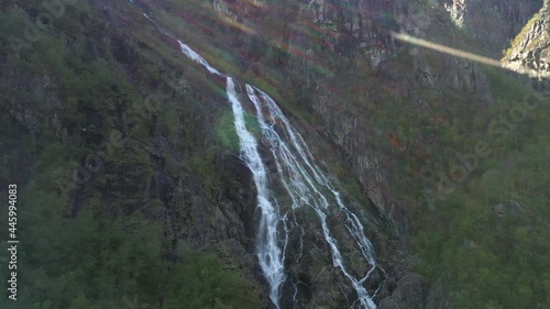 Drone shot of waterfall in Norway, sun flare in top of frame. photo