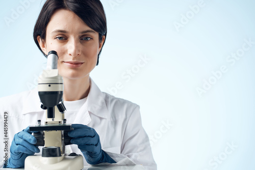 Woman in white coat laboratory science microscope analyzes
