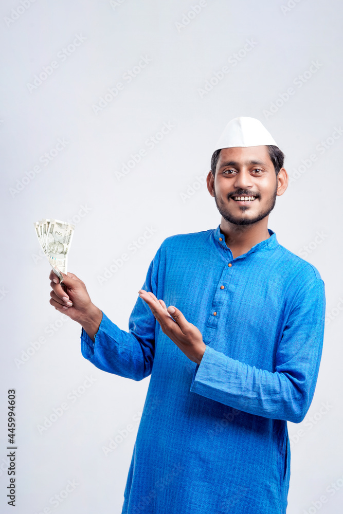 Young Indian farmer posing with currency on white background. Young Indian farmer posing with currency on white background.
