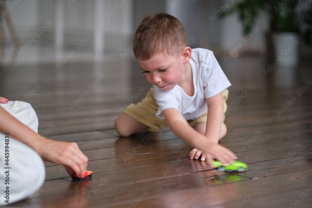Expressive baby boy playing with a toy car with mother. Expressive baby boy playing with a toy car with mother.