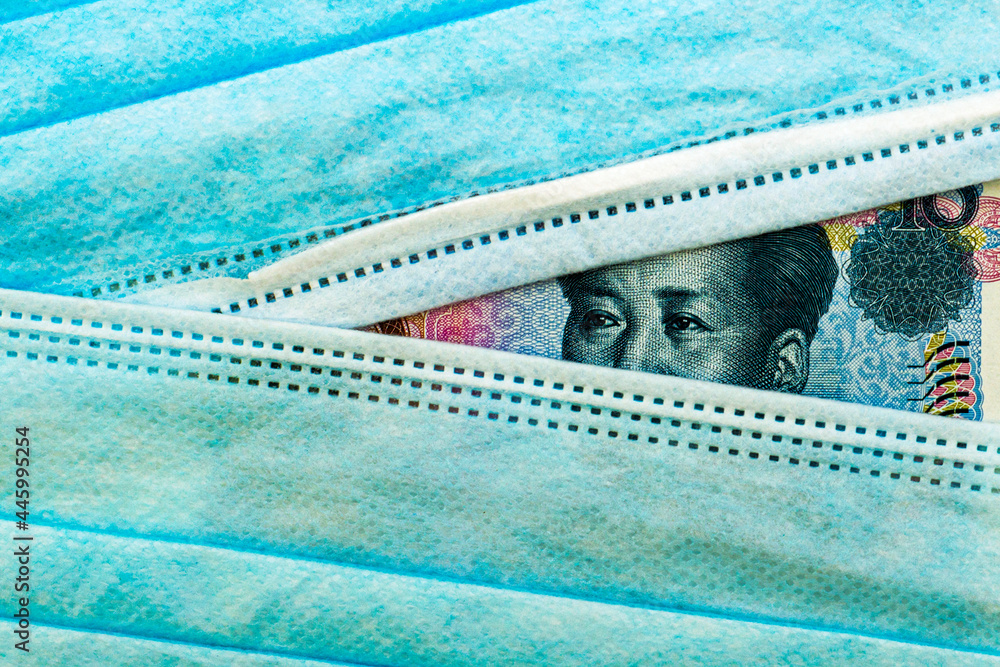 the Chinese yuan currency peeks out from under medical hygiene masks