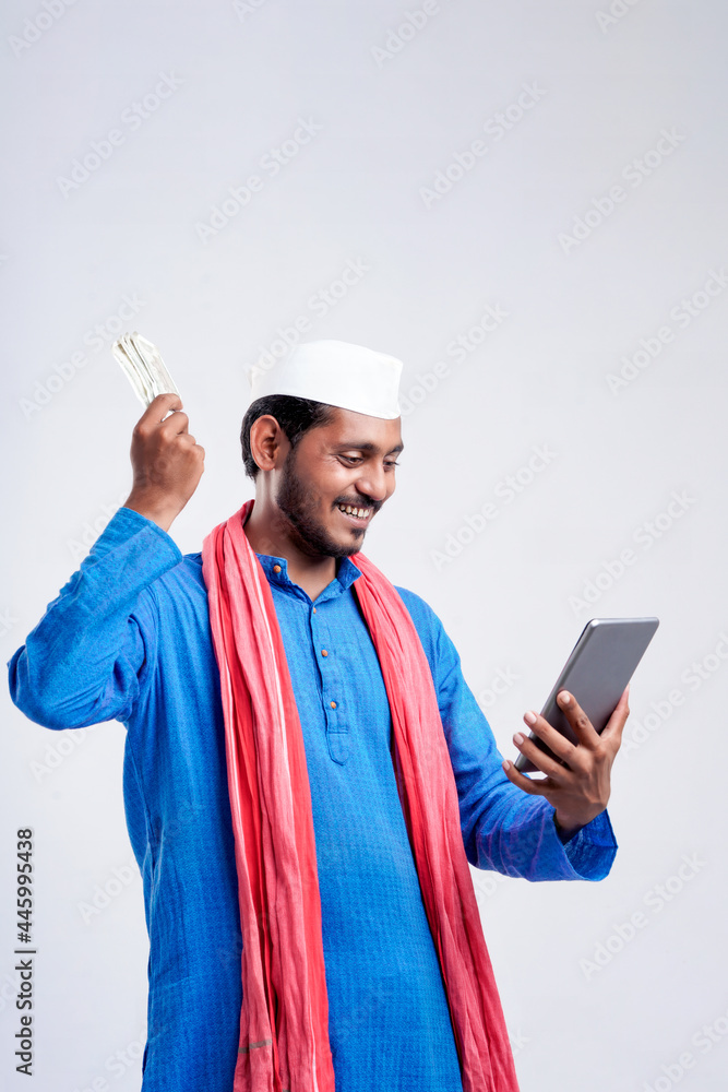 Young indian farmer using smartphone and showing money on white background. Young indian farmer using smartphone and showing money on white background.