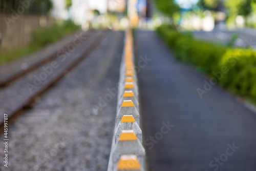 Wallpaper Mural ローカル線の線路と歩道の間にある頂部が黄色のコンクリートの垣根 Torontodigital.ca