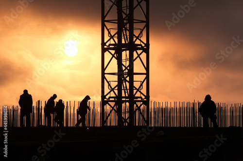 Industrial landscape against the background of a disturbing sky, silhouette of metal structures of a house construction site