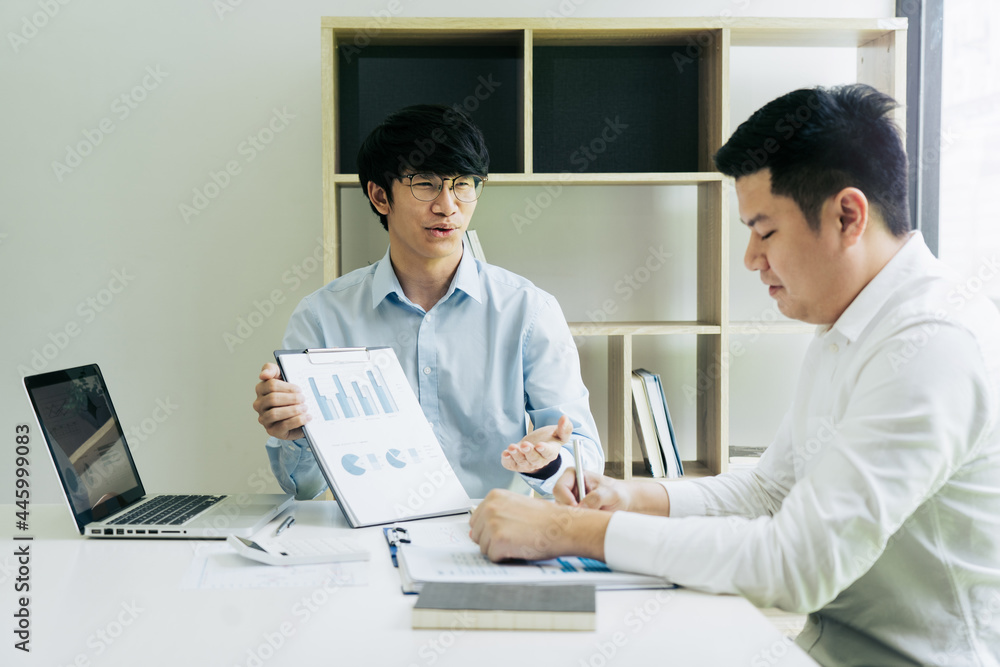 Businessman explaining financial budget figures in report paper to colleagues. Businessman explaining financial budget figures in report paper to colleagues.