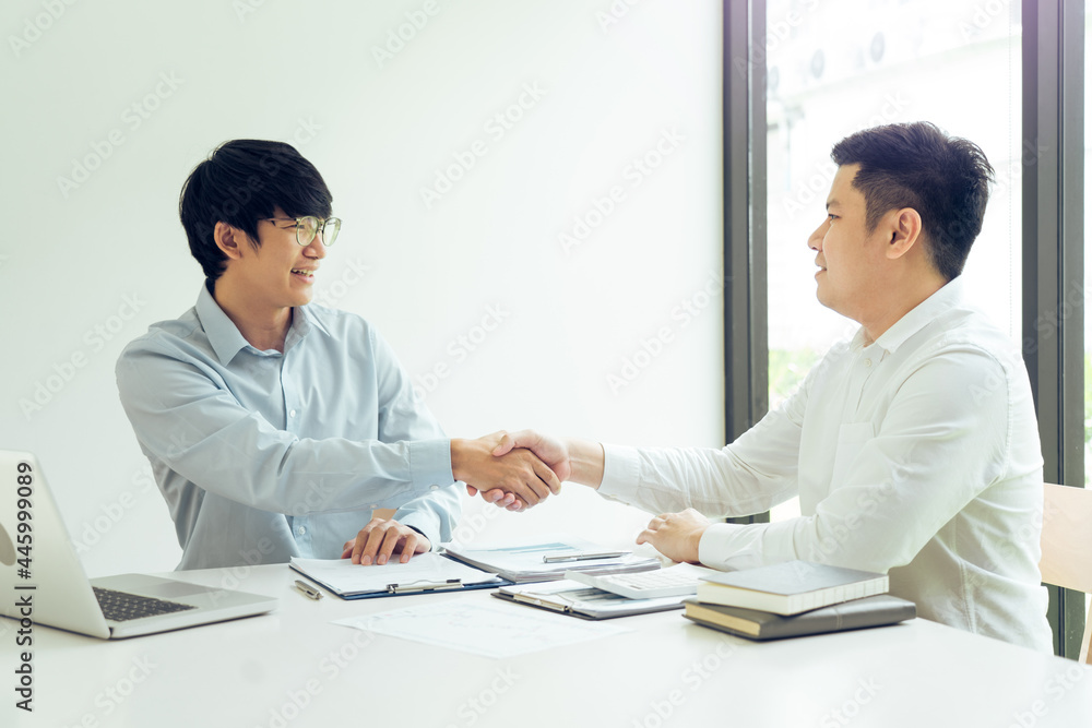 Two businessmen shaking hands as they agree on the company's budget. Two businessmen shaking hands as they agree on the company's budget.
