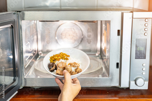 Open Microwave Oven Door And Preparing Food At Home.