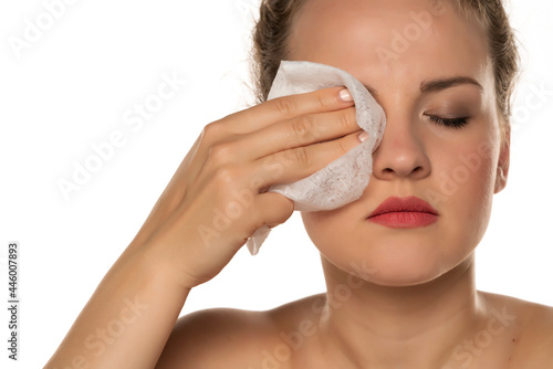 woman cleans makeup from her face with a wet wipe