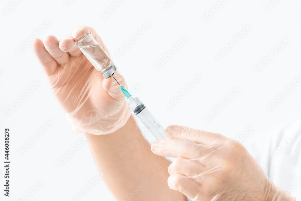 Syringe and ampoule with medicine in the hands of a doctor on a gray background Syringe and ampoule with medicine in the hands of a doctor on a gray background