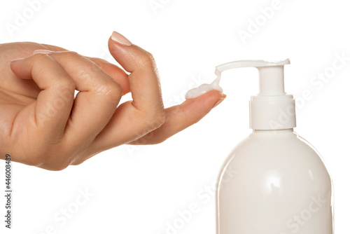 cosmetic product with a pump throws the cream on a woman's finger