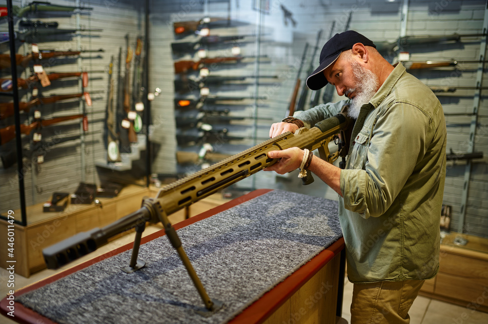 Bearded man reload powerful rifle in gun store Bearded man reload powerful rifle in gun store
