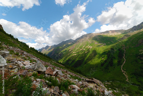 A beautiful alpine gorge of the Ullu-Murudzhu River with green meadows and mountain peaks in the Karachay-Cherkess Republic