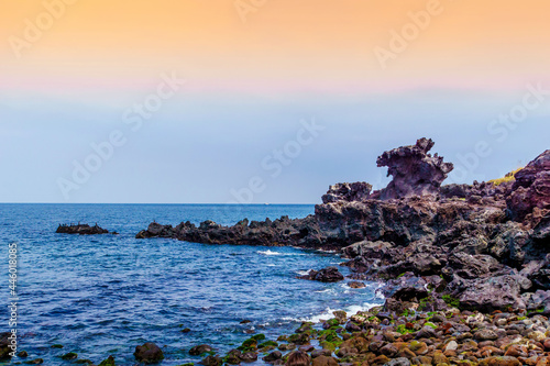 JEJU ISLAND, KOREA, SOUTH - Apr 04, 2016: Yongduam Rock on the Jeju Island surrounded by the sea during the sunset in South Korea