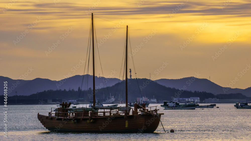 MOKPO, KOREA, SOUTH - Jun 01, 2016: Landscape of a sea with ships on it surrounded by hills during the sunset in Gatbawi Park, Mokpo