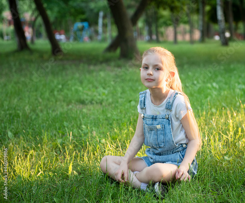 Little sad girl sitting in the park