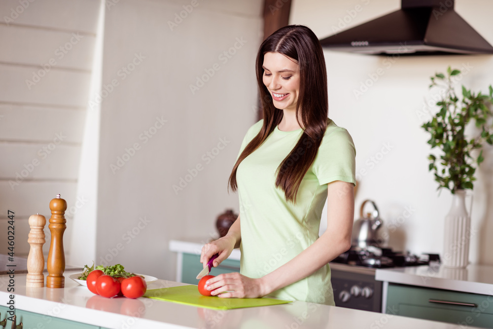 Profile photo of cheerful young lady cooking wear green t-shirt at kitchen home alone
