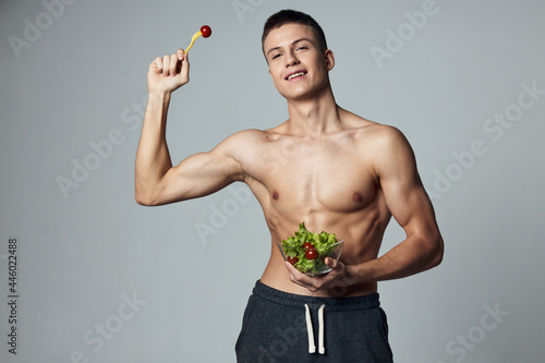 sports cheerful man with plate of salad energy diet food isolated background