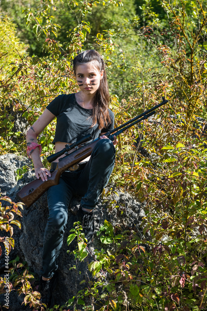 Sexy woman in top holing gun rifle wild nature