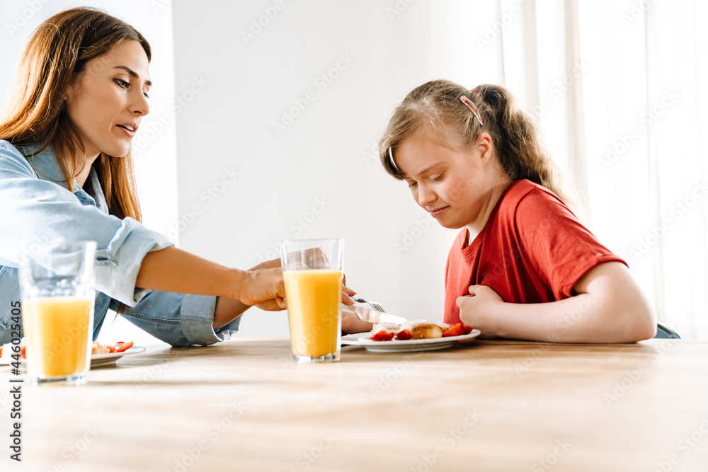White woman and her daughter with down syndrome having breakfast White woman and her daughter with down syndrome having breakfast
