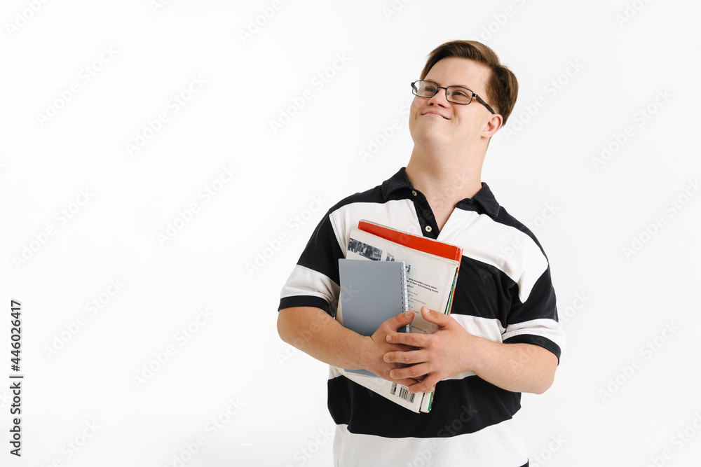 Young man with down syndrome smiling while holding exercise books Young man with down syndrome smiling while holding exercise books