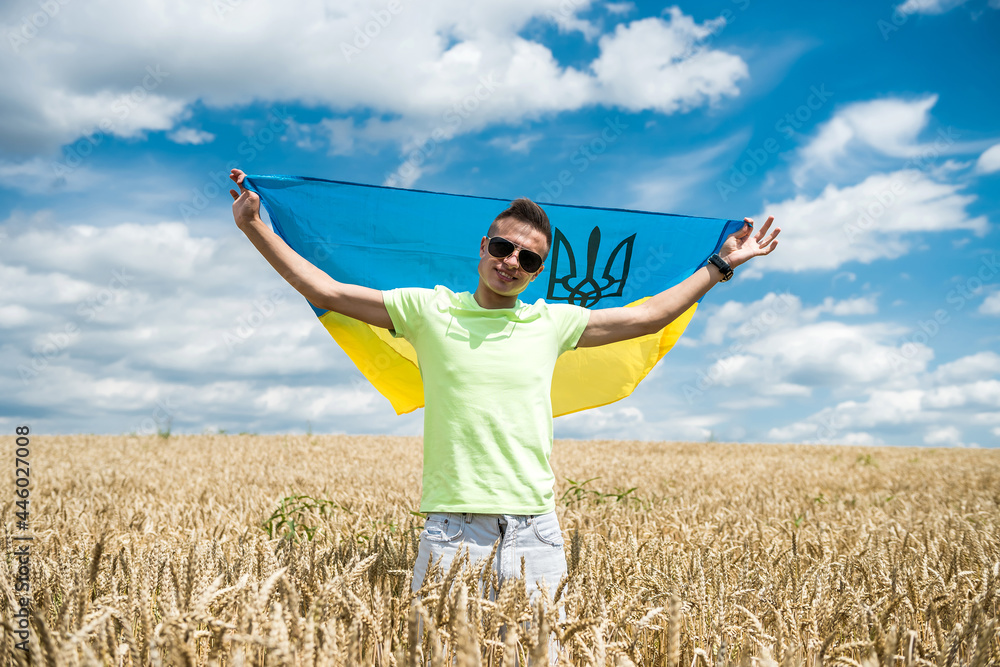 man with ukrainian flag on wheat field in summer man with ukrainian flag on wheat field in summer
