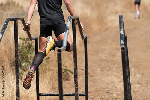фотографія Participant in extreme obstacle race climbing over hurdle