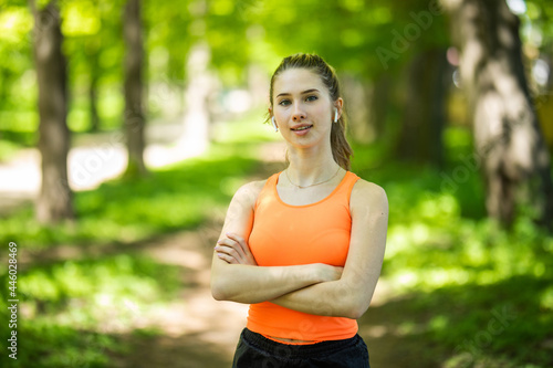 Young sportswoman using earphones doing exercise at the park © F8  \ Suport Ukraine