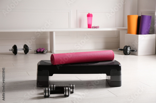 Step platform, mat and dumbbells indoors. Sports equipment