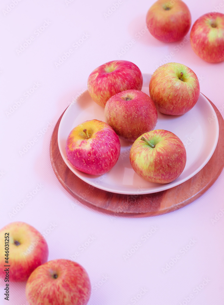 Ripe apples are lying on a pink background in a dessert pink plate Ripe apples are lying on a pink background in a dessert pink plate