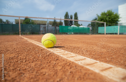 Soft focus, selective focus. Tennis ball on dry court white line. Summer sport equipment on tennis court.