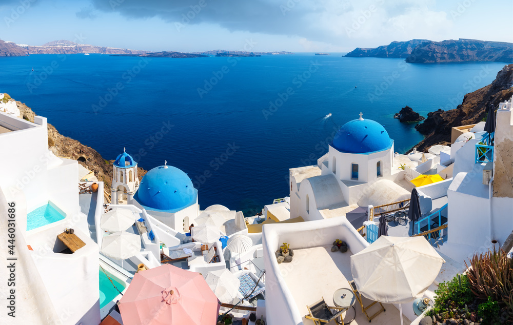 Santorini, Greece. Panoramic view of traditional houses in Santorini. Small narrow streets and rooftops of houses, churches and hotels. Oia village, Santorini Island, Greece. 