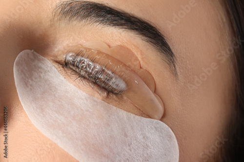 Young woman undergoing eyelash lamination, closeup. Professional service photo