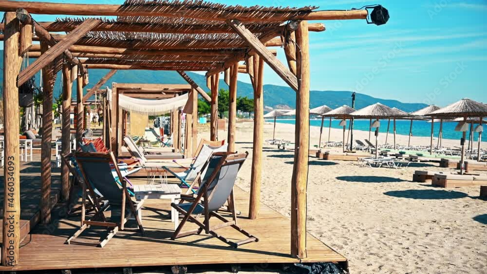 Beach on the aegean coast in Greece. Sunbeds, seats, umbrellas, sand, blue water Beach on the aegean coast in Greece. Sunbeds, seats, umbrellas, sand, blue water