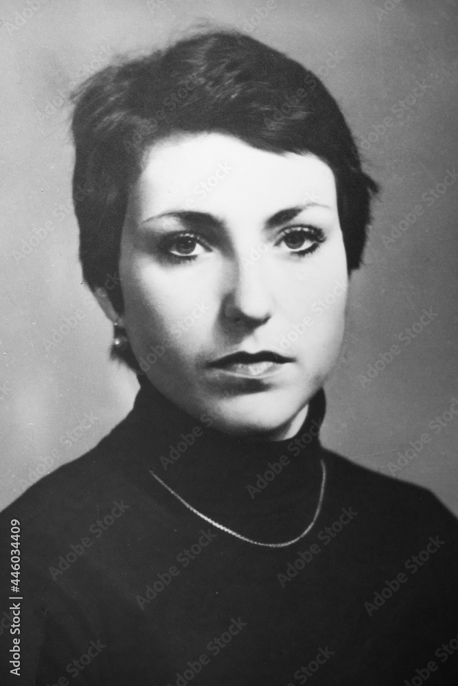 Vintage black and white portrait of  shorthaired woman, close-up. Early 1980s. Old surface, soft focus. Transferred property, family archive.