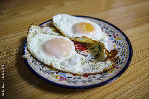 two fried chicken eggs on a plate