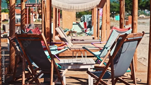 Beach on the aegean coast in Greece. Seats with table, sand photo