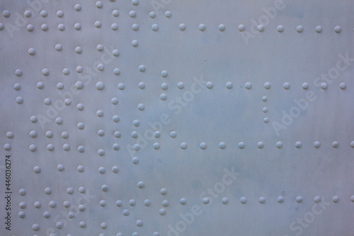 Aircraft skin with rivets. The surface of the fuselage is gray with rivets. Aviation background