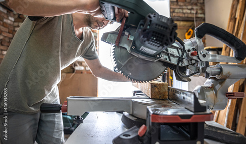 Professional carpenter working with a miter saw. photo