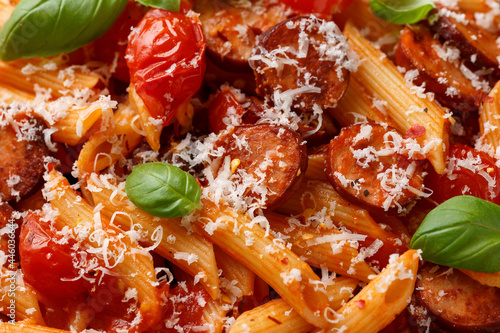 Sausage penne Pasta with tomato sauce, parmesan cheese and basil photo