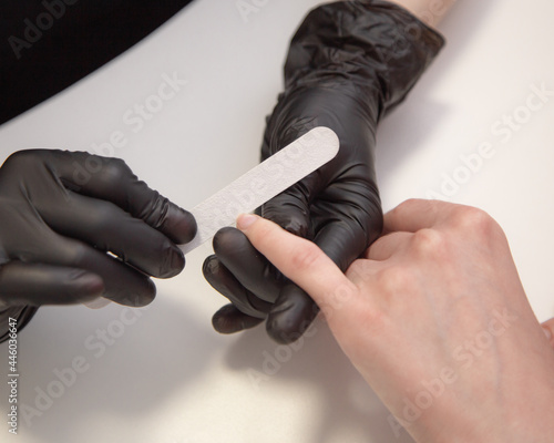 Manicurist hand polishing woman client fingernails. Safe nails procedure in luxury beauty salon 