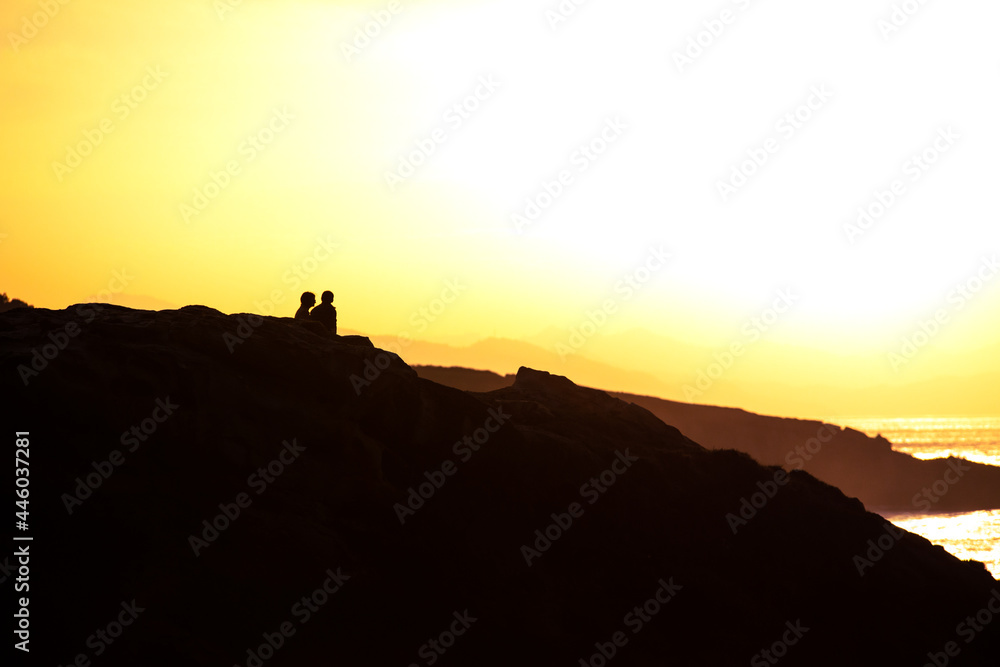 Couple enjoying the sunset at the coast Couple enjoying the sunset at the coast