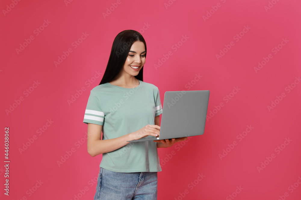 Young woman with modern laptop on pink background Young woman with modern laptop on pink background