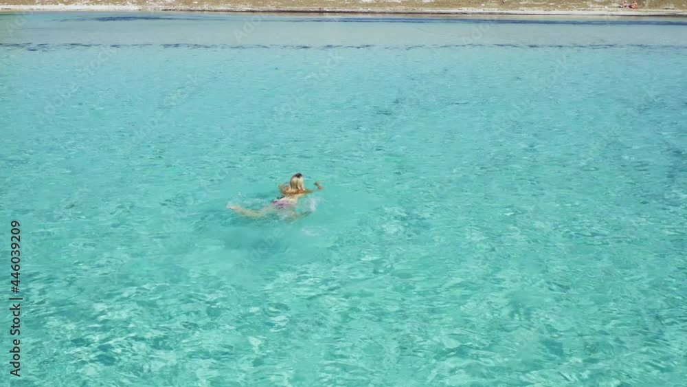 Aerial view of a girl floating in the turquoise sea of the Sakarun beach, Adriatic Sea, Croatia Aerial view of a girl floating in the turquoise sea of the Sakarun beach, Adriatic Sea, Croatia