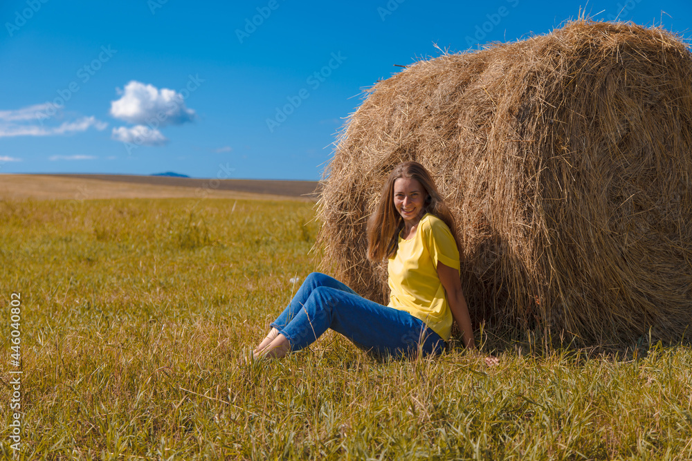 a girl is sunbathing in the hay. village life: harvesting hay for the winter. animal feed. a girl is sunbathing in the hay. village life: harvesting hay for the winter. animal feed.