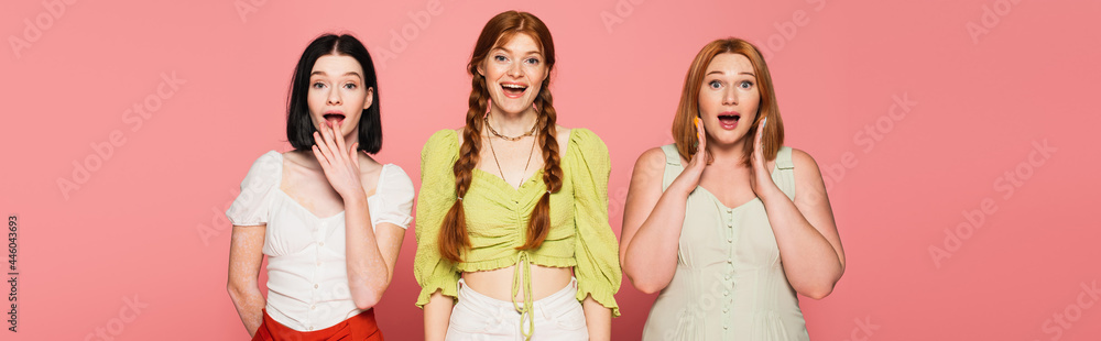 Amazed body positive friends looking at camera isolated on pink, banner Amazed body positive friends looking at camera isolated on pink, banner