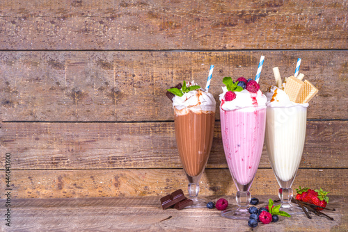Summer refreshing drinks, milkshakes, crazy shakes with ice cream, berries, vanilla, chocolate. On wooden  background