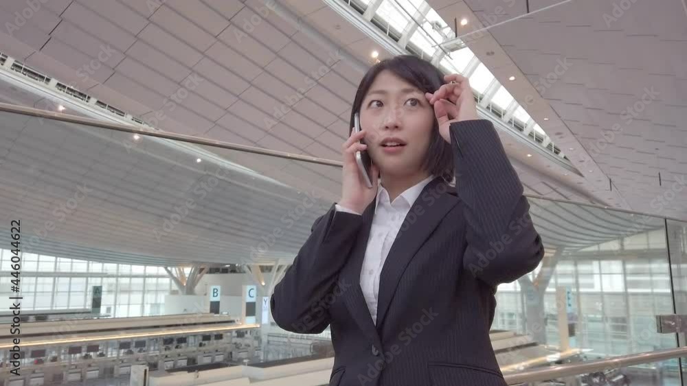 時間を気にして電話をする女性 時間を気にして電話をする女性