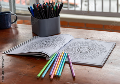 mandala book for coloring with crayons in a desk in home office