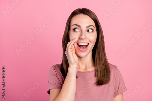 Photo of funny impressed woman dressed casual clothes arm mouth looking empty space smiling isolated pink color background